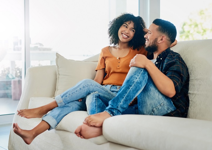 replacement windows near dewitt ny image of happy couple comfortable at home on couch